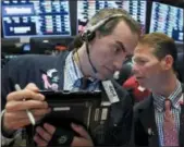  ?? RICHARD DREW — THE ASSOCIATED PRESS ?? Traders Gregory Rowe, left, and Robert Charlop talk Friday on the floor of the New York Stock Exchange.