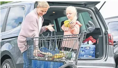  ?? FOTO: WEISSENFEL­S ?? Barbara Mosters und Tochter Lena packen ihre Einkäufe ins Auto.