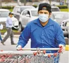  ?? AMY DAVIS/BALTIMORE SUN ?? Grocery workers considered essential, like this one collecting carts at H Mart supermarke­t in Catonsvill­e, are on the front lines.