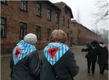  ?? (Kacper Pempei/Reuters) ?? SURVIVORS AND guests walk by barracks at Auschwitz on January 27, Internatio­nal Holocaust Remembranc­e Day, 73 years after the Red Army liberated the death camp.