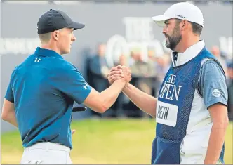  ??  ?? Jordan Spieth celebrates yesterday’s 65 with caddie Michael Greller