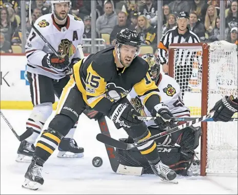  ?? Peter Diana/Post-Gazette photos ?? Blackhawks goalie Corey Crawford was tough on the Penguins all game. Here, Riley Sheahan battles for loose puck in front of him Saturday night at PPG Paints Arena.