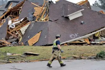  ?? AP PHOTO/BUTCH DILL ?? A firefighte­r surveys damage to a house after a March 25 tornado touched down south of Birmingham, Ala., in the Eagle Point community.