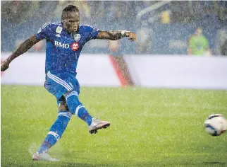  ?? PETER MCCABE/THE CANADIAN PRESS ?? Impact’s Didier Drogba shoots the ball toward New England’s goal to score in Montreal Saturday. Drogba has four goals and an assist in four MLS games since joining the Impact in July.