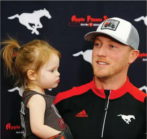  ?? LEAH HENNEL ?? Bo Levi Mitchell holds his daughter Ele, 2, as he speaks to members of the media in Calgary on Tuesday after announcing he has signed a new four-year deal with the Calgary Stampeders, noting he’s “trying to be one of the best that’s ever played.”