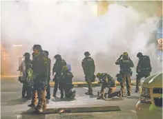  ?? NICK OZA FOR USA TODAY ?? Ferguson, Mo., police try to control a crowd after they fired tear gas near Ferguson City Hall in November 2014.