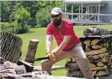  ??  ?? Nate Thames chops firewood at the family’s home in Vershire, Vt., where they moved in 2016 from Cambridge, Mass., where they still own a house.