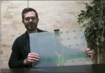  ?? IVAN MORENO — THE ASSOCIATED PRESS ?? Scanalytic­s cofounder and CEO Joe Scanlin holds a smart floor sensor his company creates that track people’s movements in Milwaukee. The sensors are among the tools retailers are using to gain insights on consumer habits.