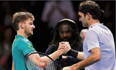  ?? — Reuters ?? Well played: David Goffin (left) shaking hands with Roger Federer after winning their semi-final match in the ATP Finals at the O2 Arena in London on Saturday.