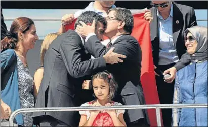  ?? REUTERS ?? El primer ministre, Davutoglu, fa un petó al cònsol turc a Mossul, Öztürk Yilmaz, en arribar a Ankara