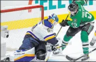  ?? Tony Gutierrez The Associated Press ?? Blues goalie Jordan Binnington blocks a shot by Stars left wing Jason Robertson in the first period of Dallas’ 2-1 shootout win Wednesday.