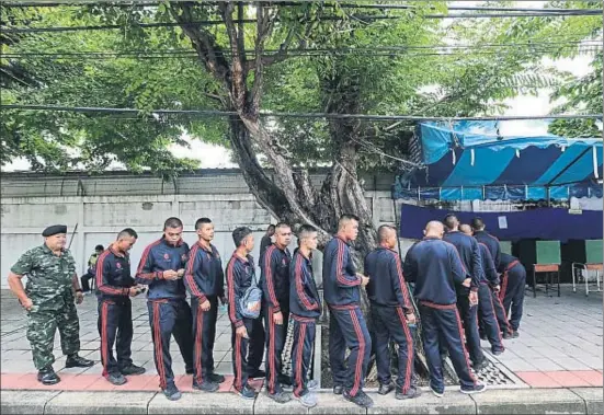  ?? DARIO PIGNATELLI / BLOOMBERG ?? Cua de soldats ahir a Bangkok per votar en el referèndum propiciat per l’exèrcit per dotar Tailàndia d’una nova Constituci­ó