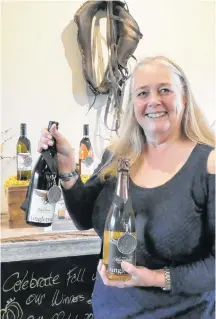  ??  ?? Singletree Winery owner, Debbie Etsell, holds a pair of her award-winning wines.