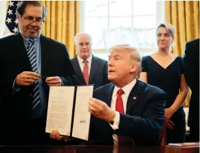  ?? JIM WATSON / AFP / GETTY IMAGES ?? United Steelworke­rs Union Internatio­nal President Leo Gerard, left, looks on after Donald Trump signs a tariff bill in the Oval Office. The inclusion of Canada in the list of countries affected by Trump’s trade action has left many USW union members in Canada on the wrong side of the tariff wall, John Ivison writes.