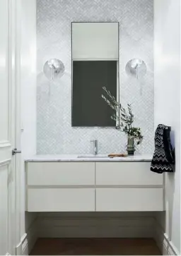  ??  ?? POWDER ROOM Herringbon­e ‘Bianco Carrara’ marble mosaic tiles from Bespoke Tile & Stone by Earp Bros pack a tactile punch in the powder room (top left), as does a pair of Mondoluce ‘Spillray’ wall lights. Custom 2-pac joinery by Precision Cabinets in Dulux Natural White is teamed with a Neolith Arctic White vanity top for a sleek impression.