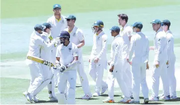  ?? — AFP photo ?? India's batsman Ishant Sharma walks back to the pavilion after his dismissal as Australian players celebrate during day five of the second Test cricket match between Australia and India in Perth on December 18, 2018.