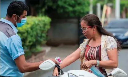  ?? Photograph: Inti Ocón/ AFP/Getty Images ?? A health worker measures a woman’s temperatur­e at the entrance of Managua Cathedral in Managua, Nicaragua.