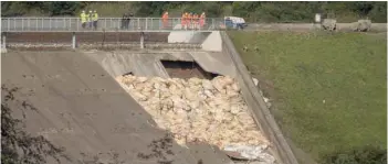  ?? — AFP ?? Engineers and members of the emergency services assess the damaged spillway of the Toddbrook Reservoir dam, above the town of Whaley Bridge in northern England on Sunday.