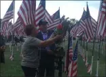  ?? KEVIN MARTIN — THE MORNING JOURNAL ?? Gino Zimmer, right, lays a wreath at the opening ceremony of the Ohio Flags of Honor memorial at Sheffield Lake’s Shoreway Shopping Center on Sept. 13.