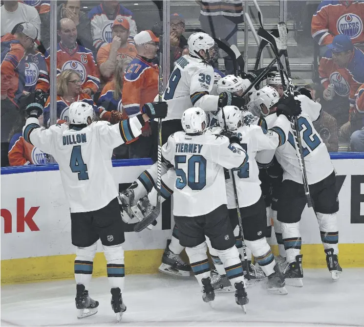  ?? ED KAISER ?? San Jose Sharks teammates crowd around forward Melker Karlsson after his overtime goal against the Edmonton Oilers in Game 1 on Wednesday night at Rogers Place.