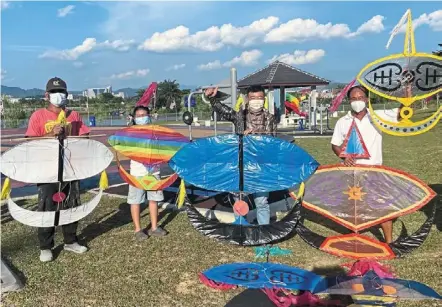  ?? ?? Soaring hobby: tan (second from right) and his friends showing off their wau at the Sungai Chua recreation­al park in Kajang. — bernama