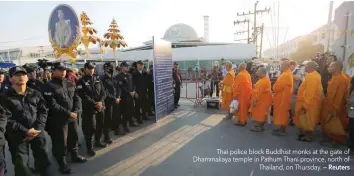  ?? — Reuters ?? Thai police block Buddhist monks at the gate of Dhammakaya temple in Pathum Thani province, north of Thailand, on Thursday.