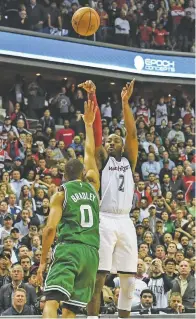  ?? TONI L. SANDYS/THE WASHINGTON POST ?? Wizards guard John Wall shoots the game-winning 3-pointer over Celtics guard Avery Bradley on Friday in Washington. The win forces Game 7 in the Eastern Conference semifinal.