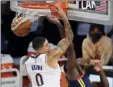  ?? AP photo ?? Kyle Kuzma of the Lakers dunks on the Warriors’ Eric Paschall on Sunday.