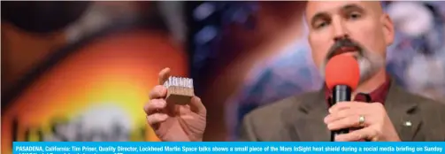  ?? — AFP ?? PASADENA, California: Tim Priser, Quality Director, Lockheed Martin Space talks shows a small piece of the Mars InSight heat shield during a social media briefing on Sunday at NASA’s Jet Propulsion Laboratory.