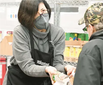  ?? AMY SHORTELL/THE MORNING CALL ?? Gloria Fiorenti helps clients select products Thursday at the Allentown Area Ecumenical Food Bank in Allentown. Starting in March, Supplement­al Nutrition Assistance Program recipients will no longer receive an additional emergency allotment payment.