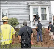  ?? AP/WINSLOW TOWNSON ?? A police officer climbs out the window of an evacuated house Friday in Andover, Mass., after checking for gas and making sure that the gas was turned off. Houses in three Boston-area towns were damaged Thursday by fiery gas explosions. Some 8,000 people were displaced.