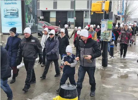  ?? ERIN PETROW ?? Participan­ts of the March a Mile Walk to End Homelessne­ss aiming to fund safety initiative­s, make their way out of the Lighthouse Supported Living Centre and up 2nd Avenue in Saskatoon on Saturday. The effort drew about 100 people including the mayor...