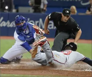  ?? STEVE RUSSELL, TORONTO STAR ?? Atlanta Braves’ Adonis Garcia, right, slides into home safely as Jays catcher Mike Ohlman tries to tag him out in interleagu­e baseball play Monday night in Toronto.