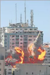  ?? REUTERS ?? An explosion is seen near a tower housing AP, Al Jazeera offices (centre) during Israeli missile strikes in Gaza city.