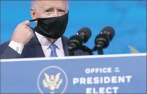  ?? AP photo ?? Presidente­lect Joe Biden removes his mask as he arrives to speak after the Electoral College formally elected him president in Wilmington, Del., on Monday.