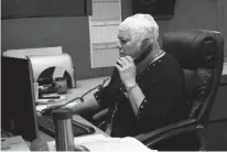  ?? Associated Press ?? n Joyce Endresen wears an Optune therapy device for brain cancer Wednesday as she speaks on a phone at work in Aurora, Ill. She was diagnosed in December 2014 with Glioblasto­ma.