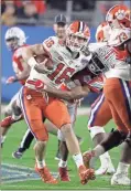  ??  ?? Ohio State cornerback Shaun Wade, right, tackles Clemson quarterbac­k Trevor Lawrence during the first half of the Fiesta Bowl NCAA college football playoff semifinal in Glendale, Ariz. Wade was ejected from the game for targeting.