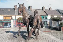  ?? PHOTO: ANDREAS F. BORCHERT, CC BY-SA 3.0 DE ?? Left: Horse and handler sculpture by James McCarthy in Ballinaslo­e.