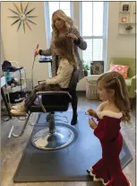  ?? WILLIAM TILTON — THE NEWS-HERALD ?? Olivia Laccheo gets her hair styled by Mallory Boldan as Juliana Bruno looks on during the Styles with Santa event at Eden Off the Avenue in Mentor on Nov. 26.