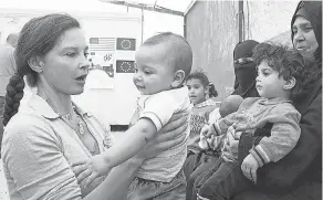  ?? KHALIL MAZRAAWI/ AFP/ GETTY IMAGES ?? Ashley Judd, actor and a United Nations Population Fund’s Goodwill Ambassador, visits with a Syrian family at a refugee camp in Jordan in 2016.