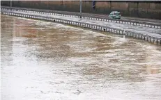  ?? FOTO: DPA ?? Nur noch die Polizei fährt über die Autobahn 620 in Saarbrücke­n. Der Pegel der Saar steigt weiter an.