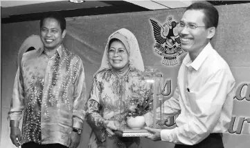  ??  ?? (From right) Joni hands over a memento to Fatimah, as Dr Abdul Rahman looks on.