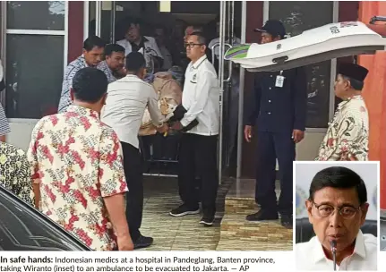  ??  ?? In safe hands: Indonesian medics at a hospital in Pandeglang, Banten province, taking Wiranto (inset) to an ambulance to be evacuated to Jakarta.