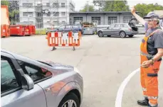  ??  ?? Damit nicht zu viele Autos in den Langenarge­ner Wertstoffh­of einfahren, lenkt und regelt Martin Rentschler den Verkehr auf dem Gelände im Rahmen einer Blockabfer­tigung.