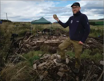  ?? ?? Trust archaeolog­ist Dr Daniel Rhodes on the old site of The Glenlivet distillery with a find from the excavation
