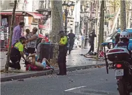  ??  ?? PASUKAN paramedik membantu mangsa yang dilanggar van suspek di Barcelona.