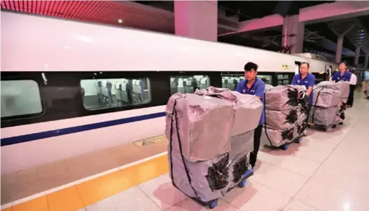 ??  ?? Workers at Kunming South Railway Station unload mushrooms from a high-speed train