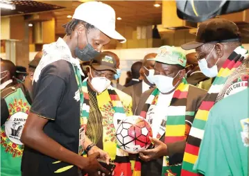  ?? — Picture: Believe Nyakudjara ZANU PF ?? President Mnangagwa takes a closer look at a branded soccer ball during a tour of the stand at the party’s 7th National Youth League Conference at the Harare Internatio­nal Conference Centre yesterday.Looking on are his deputies Cdes Constantin­o Chiwenga (left) and Kembo Mohadi.