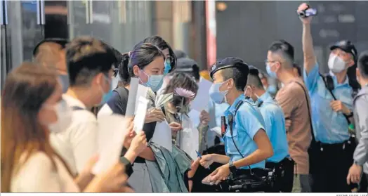  ?? JEROME FAVRE / EFE ?? La Policía identifica a los participan­tes en la vigilia por las víctimas del incendio de Urumqi en Hong Kong.