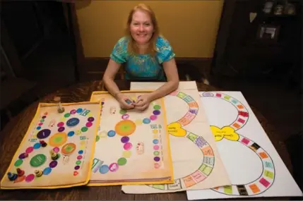  ?? VANESSA TIGNANELLI, RECORD STAFF ?? Jennifer Davis shows how her board game “Exit Matters” evolved. The game helps facilitate discussion­s about death.